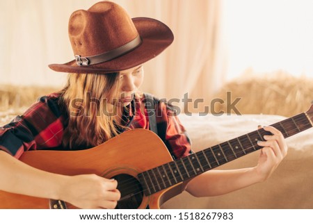 Music Concepts. Asian Caucasian girl in countryside playing guitar. Asian women relaxing with music. Asian women have a happy lifestyle.