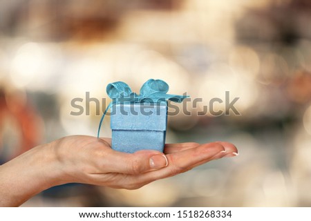 Woman hand holds gift box on abstract background