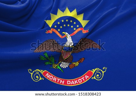 Realistic flag State of North Dakota on the wavy surface of fabric