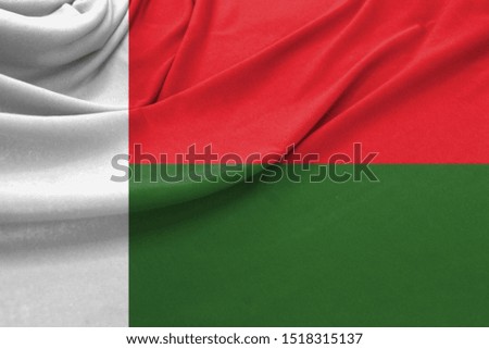 Realistic flag of Madagascar on the wavy surface of fabric