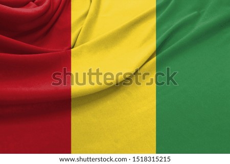Realistic flag of Guinea on the wavy surface of fabric