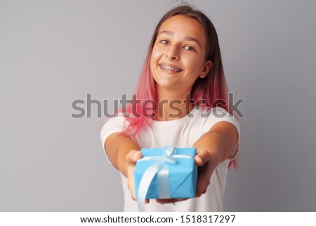 Nice teen girl holding gift box in her hands