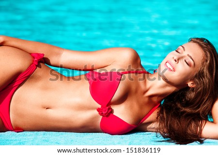 smiling beautiful young woman in bikini by the pool 