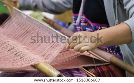 Closeup of skillful hill tribe woman's hand doing colorful cotton cloth weaving. Show traditional textile production and simply way of life by self- reliance practice. Thailand. Royalty-Free Stock Photo #1518386609