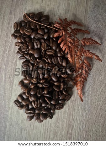 a pile of coffee beans with autumn fall leaves