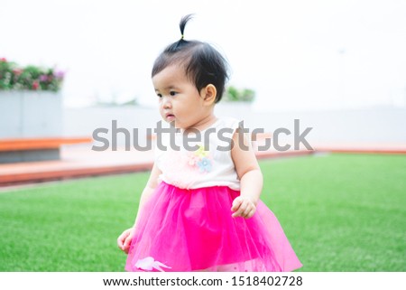 cute baby girl play on green background 
