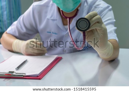 Men wore white shirts are holding a stethoscope.During the physical examination the patient's body at the hospital's office.