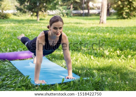 Beautiful woman doing Pilates in the green park