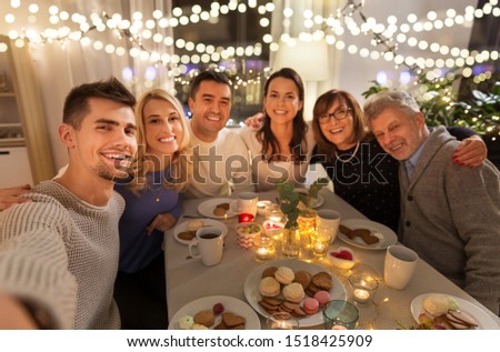 celebration, holidays and people concept - happy family having tea party at home and taking selfie