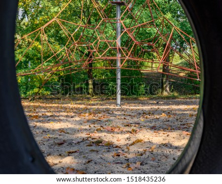 Children's playground in Germany - view through a tire swing to a climbing frame in the background.