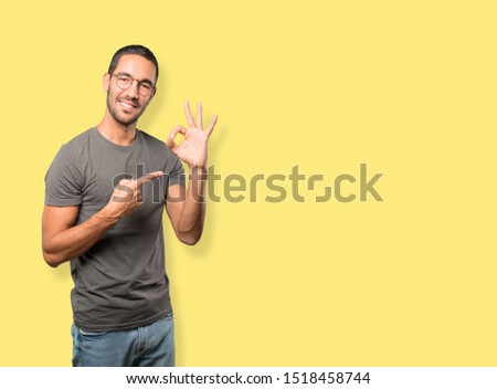 Happy young man doing an all right gesture