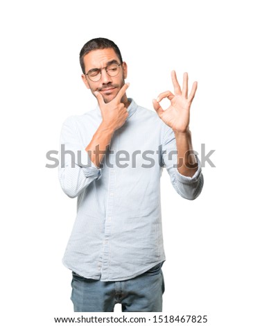 Worried young man doubting and making a gesture of approval