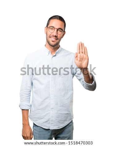 Happy young man making a gesture of stop with his palm