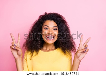 Portrait of positive cheerful african girl have holidays feel candid make v-signs wear yellow pullover isolated over pink color background