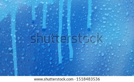 blue rainy drops on a surface going down with the piant
