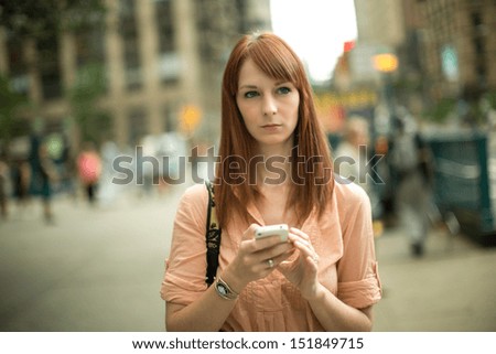 Caucasian woman female using a cellphone iPhone  walking down the streets of New York City