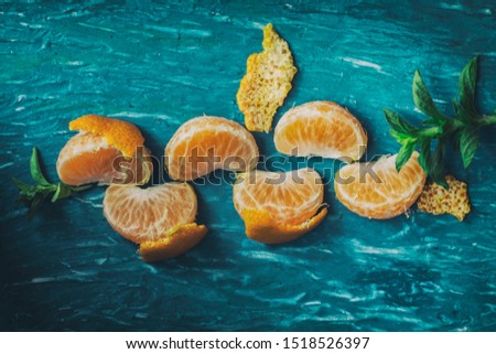 Tangerines in parts in a blue table  Royalty-Free Stock Photo #1518526397