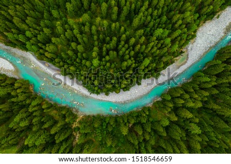 Inn River flowing in the forest in Switzerland. Aerial view from drone on a blue river in the mountains Royalty-Free Stock Photo #1518546659