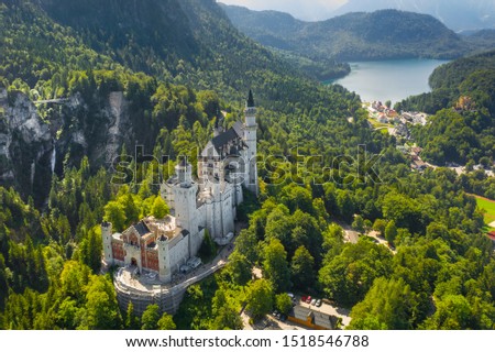 Aerial view on Neuschwanstein Castle Schwangau, Bavaria, Germany. Drone picture on Alpsee lake in Alps mountains.