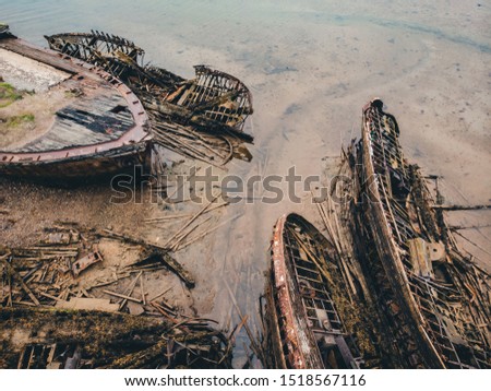 Cemetery of old ships Teriberka Murmansk Russia, wooden remains of industrial fishing boats in sea. Industrialization concept. Aerial top view.