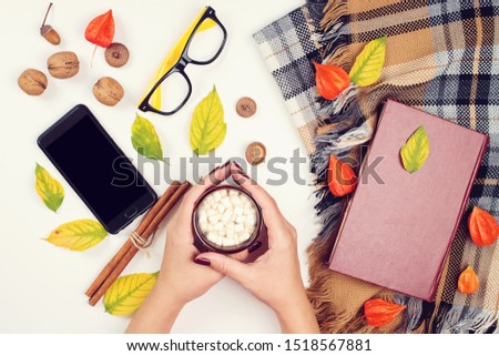 Autumn concept. Time for reading. Autumn leaves, book, eyeglasses and cup of hot chocolate. Autumn season, lifestyle and blogger work table. Top view, flat lay.