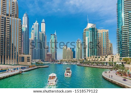 Luxury Dubai Marina skyscrapers, cruise boat and promenade in beautiful summer morning, Dubai, United Arab Emirates Royalty-Free Stock Photo #1518579122