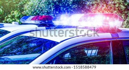 Police lights on car during traffic surveillance on the city road. Flash light on the vehicle of the Emergency Services. Red and blue flashes on the cars of the Patrol specialized unity. Conceptual.