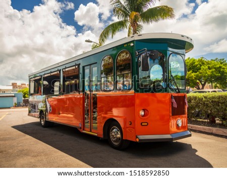 Tourists  travel on historic, orange Trolley Buses of Key West, Florida Royalty-Free Stock Photo #1518592850