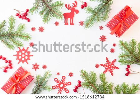 Flat lay frame with evergreen tree branch, christmas decorations and gift box on a white background