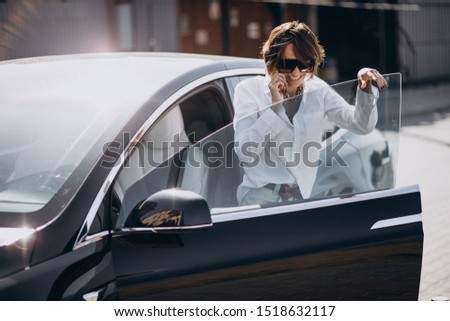 Young woman driving in car and using phone