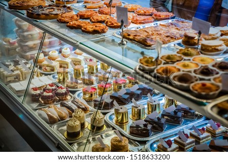 Cakes on display in patisserie shop window
 Royalty-Free Stock Photo #1518633200