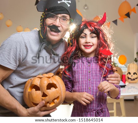 Dad with a little daughter is fooled in  halloween at home.