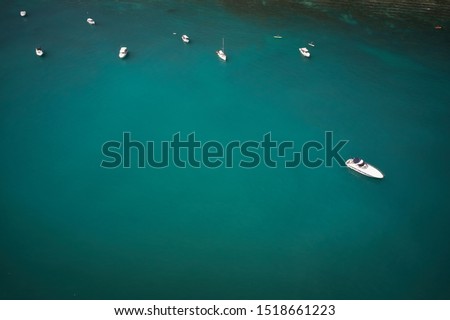 Yachts at the sea in Italy. Aerial view of luxury yacht docked in sea with turquoise clear waters