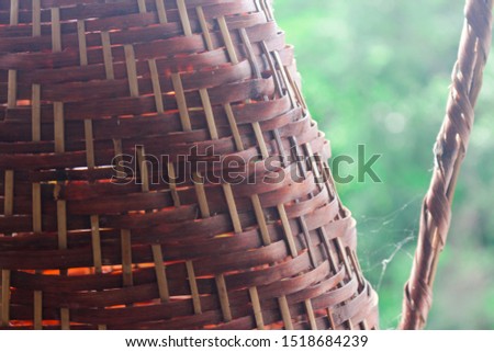 Close up photography of a brown hand-knitted wicker basket, with some spider web in the background.