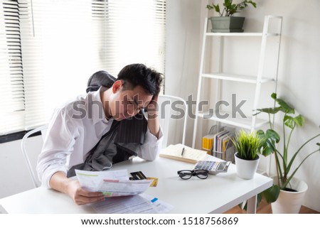 Sad confused and stressed of young Asian man holding bills letter of credit card debt, Financial money problem and tax invoice notification concept Royalty-Free Stock Photo #1518756869