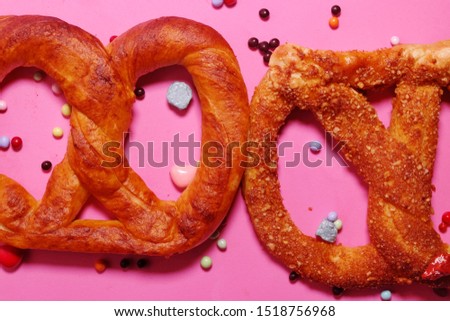 Flatlay closeup picture of two pretzels with candies insight. Sweet, fun and funky concept mood.