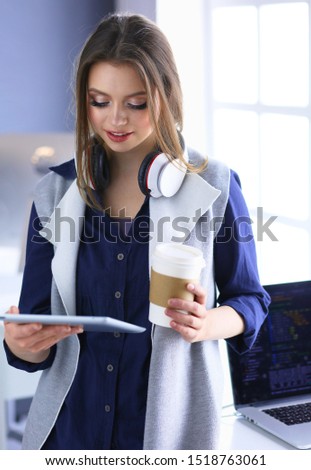 Young confident businesswoman working at office desk and typing with a laptop