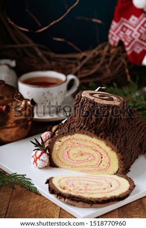 Christmas Yule log cake with edible sweet mushrooms and pine cones