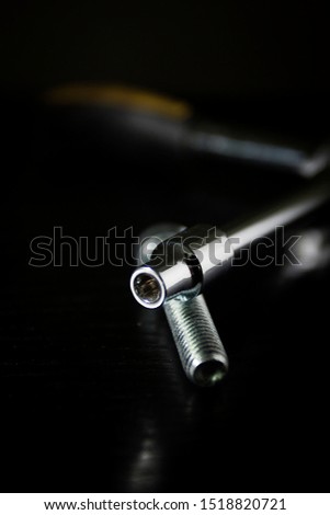 Ring wrench and bolt on a black background