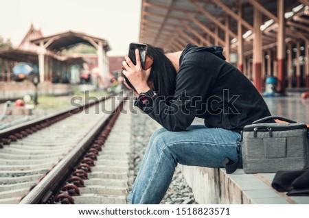 The idea of ​​unemployment, problems that women are tired from work. Sit at the train station to want to be alone