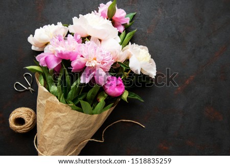Background with pink peonies on black concrete  board
