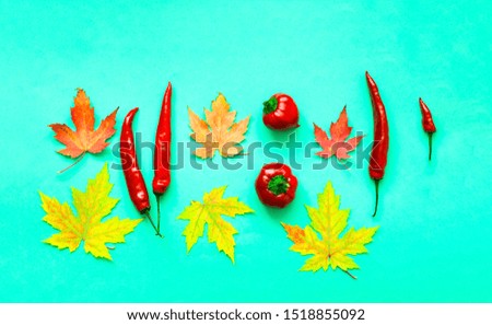 Autumn background from yellow leaves and paprika pepper. Trendy color 2020. Close-up, copy space.