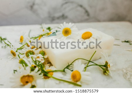 white soap with daisies on a light background