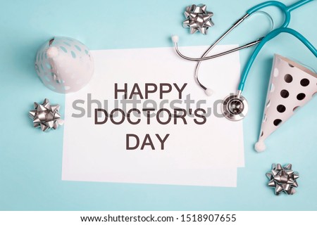 Doctor's day greeting card with stethoscope and festive caps on blue background. 
