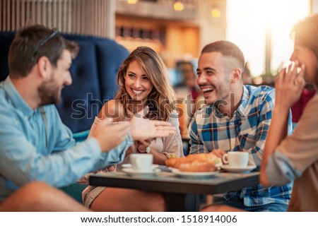 Happy friends having a great time in cafe. Friends sitting in a coffee shop, drinking coffee and having fun together. Royalty-Free Stock Photo #1518914006