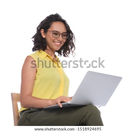 Happy young woman sitting on chair and working with laptop on white background