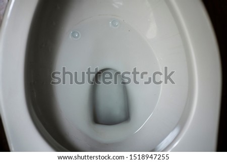 A soft-focused picture of a toilet that looks like a pareidolia in a form of a face of human who looks in shock and disbelief  Royalty-Free Stock Photo #1518947255