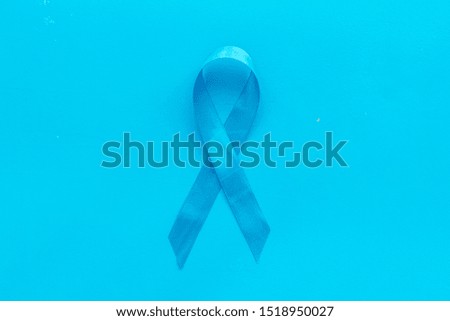 Blue ribbon as symbol disease control on blue background top view copy space