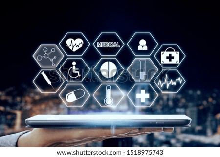 Close up of hand holding tablet with creative medical interface on blurry night city background. Medicine and innovation concept. Multiexposure