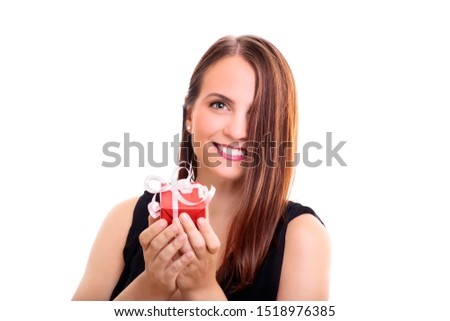 A portrait of a beautiful smiling young woman holding a wrapped gift, making an impression she's giving it to you, isolated on white background.